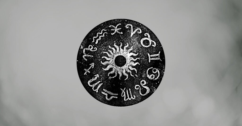 Black zodiac wheel with white astrological symbols on a soft gray background