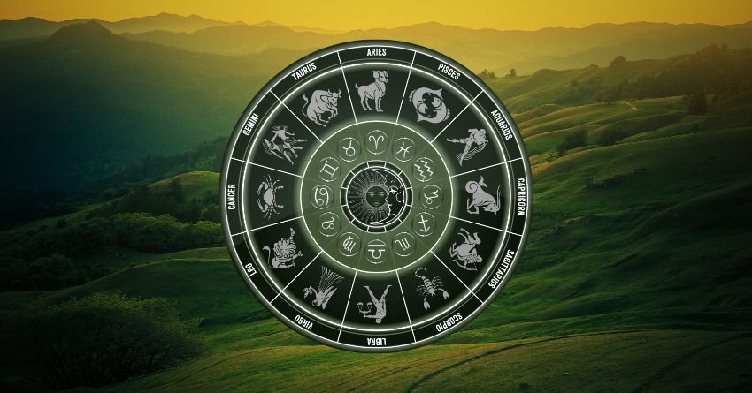 Zodiac wheel with astrological symbols over a dark green landscape beneath a dramatic golden sky