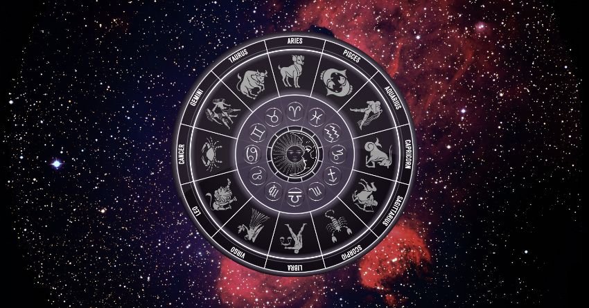 Glowing zodiac wheel with astrological symbols surrounded by red and purple cosmic clouds on a dark background