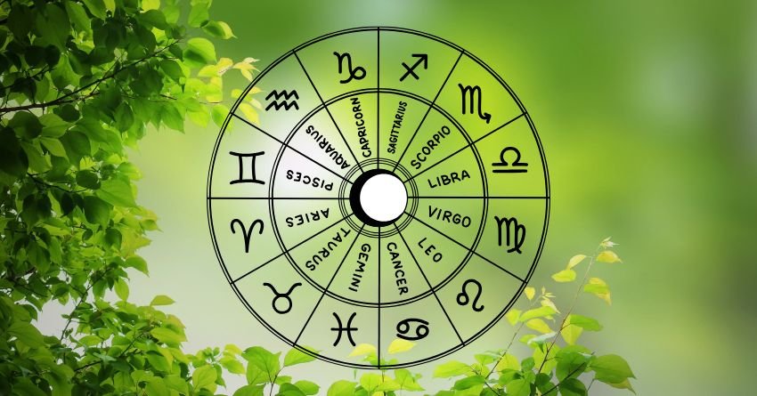 Green zodiac wheel with astrological symbols surrounded by bright leaves and natural light