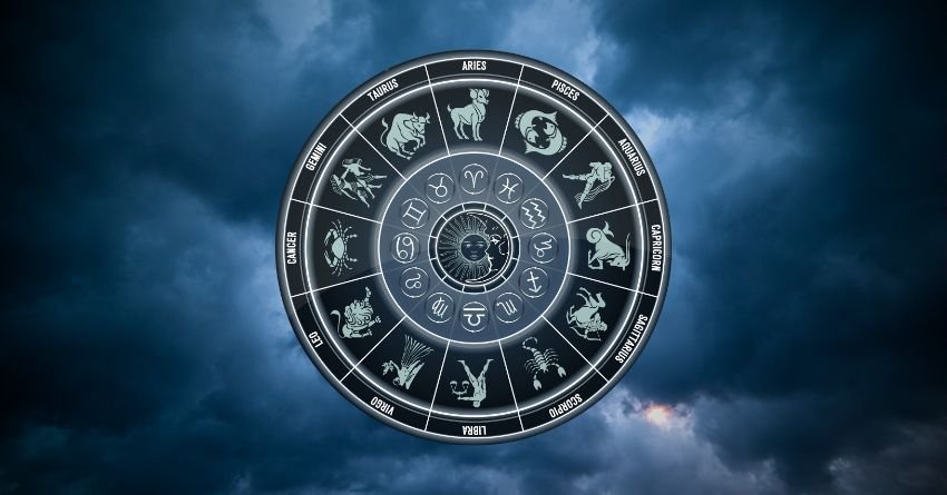 Glowing zodiac wheel with astrological symbols surrounded by dark blue cosmic clouds