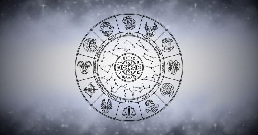 White zodiac wheel with astrological symbols glowing against a soft gray cosmic background